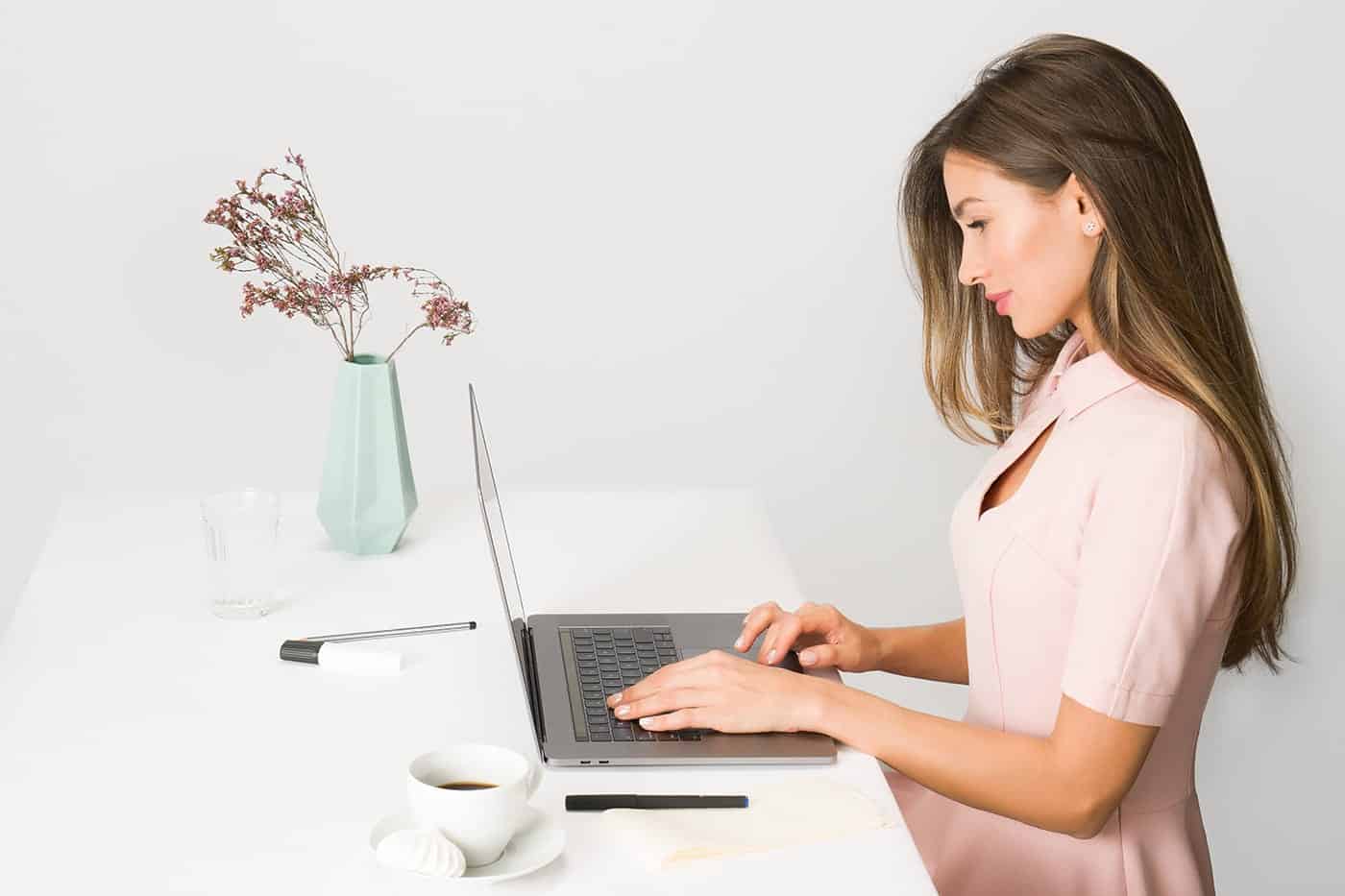 a woman sitting at a table using a laptop