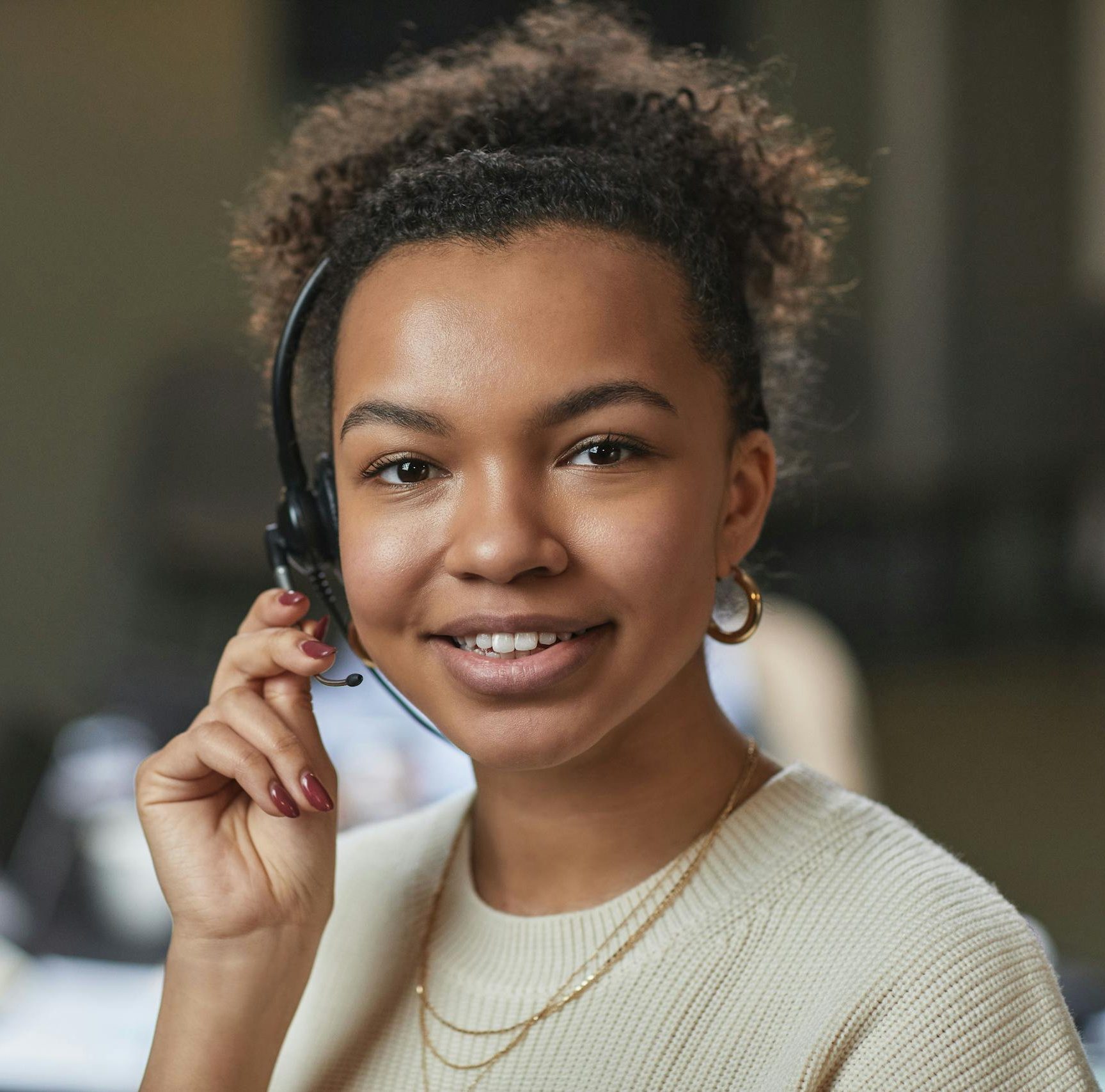 Mental Health Clinic Australia Friendly woman in a call center environment, wearing a headset and smiling.
