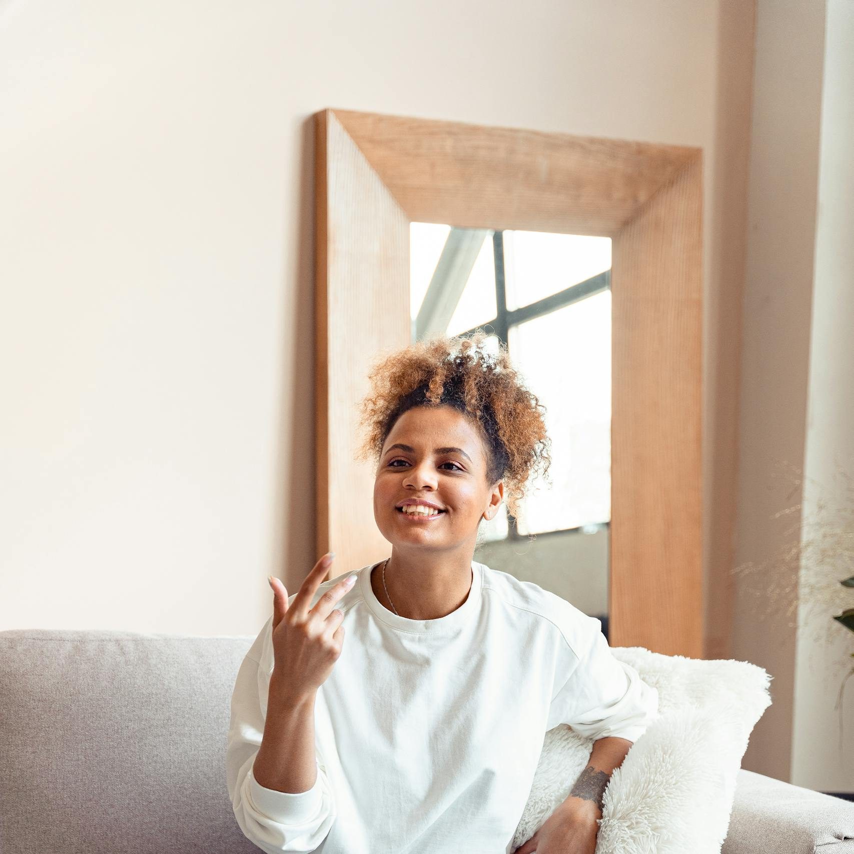 Mental Health Clinic Australia Smiling woman in a therapy session on a comfortable sofa.